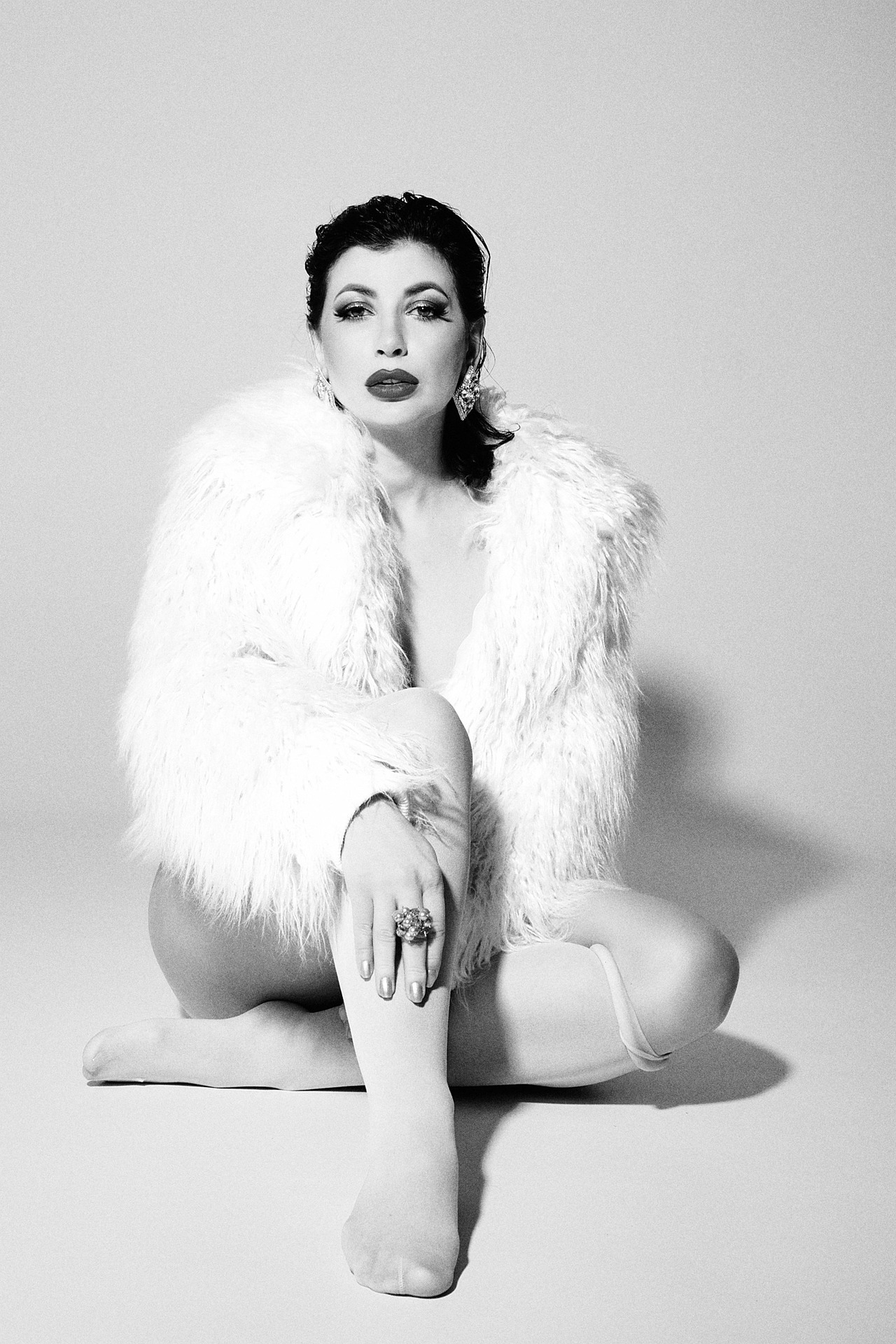 A fashionable woman in a white dress walking down a street.